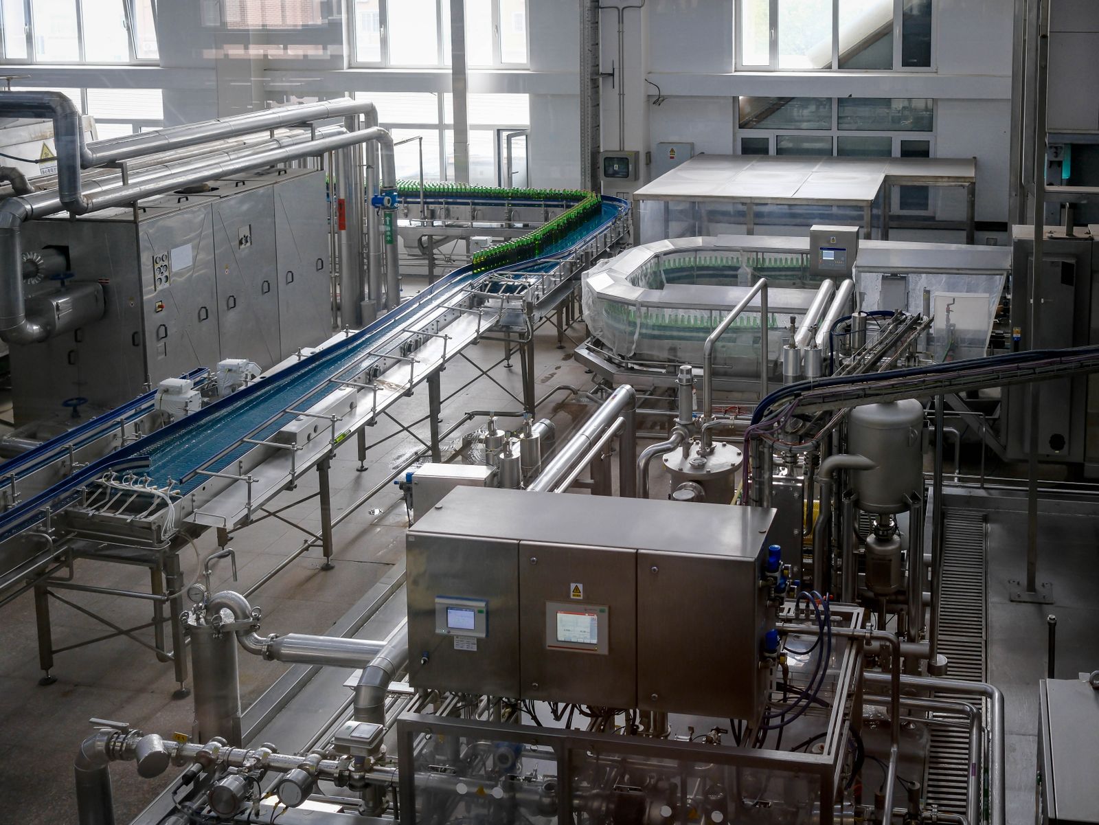 Modern beverage bottling line with bottles moving along a conveyor